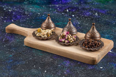 Different herbs and spices on wooden boardの写真素材