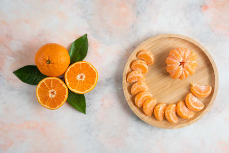 Whole and peeled clementine mandarins on grey backgroundの写真素材