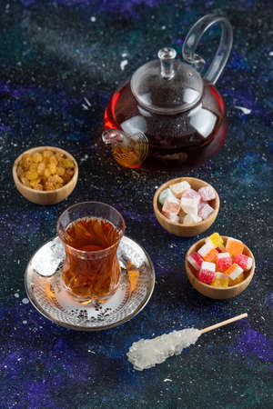 Vertical photo of tea table. Tea and candies on blue backgroundの写真素材