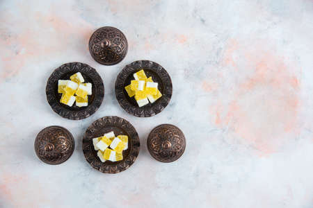 Yellow candies on crockery over white backgroundの写真素材