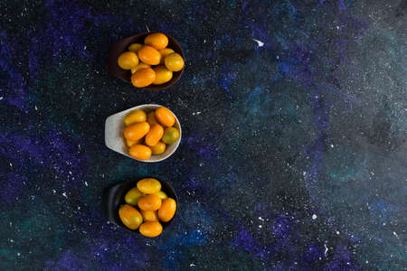 Top view of fresh kumquats on blue background, Vide angle photoの写真素材