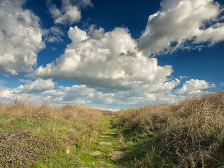 Dramatic blue sky with white clouds over the ruins of the ancient greek colony of Histria, on the shores of Black Sea. Histria is the oldest urban settlement on Romanian territoryの写真素材