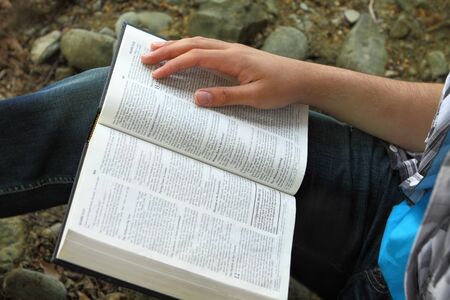 Man reading Bible, close up of Bible and hand
