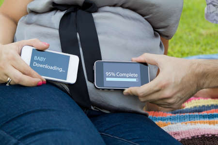 Expecting mom and dad holding smart phones