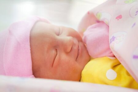 Smiling newborn girl sleeping close-up