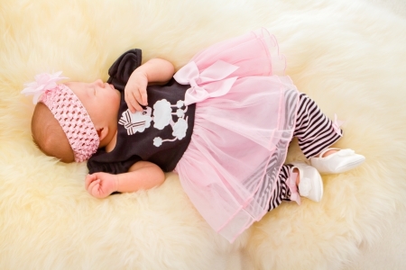 Newborn girl sleeping in cute dressの写真素材