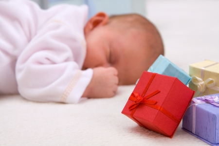 Colorful gift boxes with sleeping baby in backgroundの写真素材