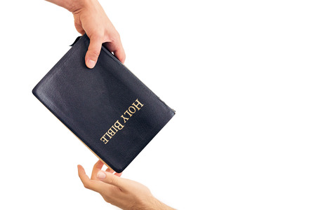Male hand giving Bible and evangelizing someone の写真素材