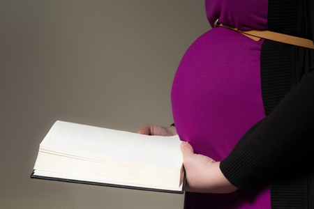 Pregnant mother reading the KJV Bible to her unborn childの写真素材