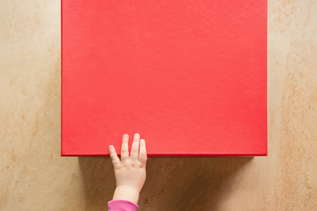 Cute Baby Hand On A Red Gift Boxの写真素材