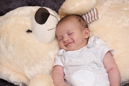 Peaceful newborn sleeping with giant fluffy teddy bear