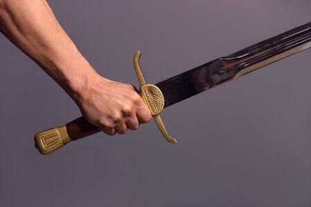 Strong young guy pointing his long sword