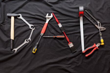 The word dad spelled out with different hand tools on Black backgroundの写真素材