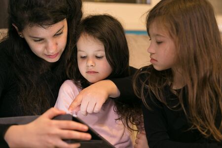 Young Mother teaching children at home on Electronic Deviceの写真素材