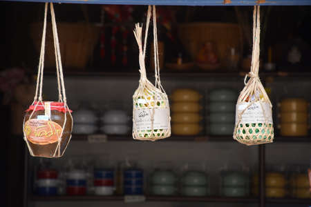 Kanchanaburi, Thailand, 09.09.2019:Hanging Traditional Thai jar filled with Thai beer and braided holding products in the Ancient Market Zone in the heritage village Mallika City R.E. 124のeditorial素材