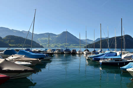 Vitznau, Switzerland 29.09.2019: Sailing boats resting in the port of Vitznau on Lake Lucerne with view of mountain rangesの写真素材