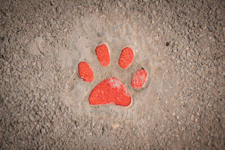 Ceramic orange colored paw shaped sign showing the walking pathway in the garden of the Tao Hong Tai Ceramics Factory in Ratchaburi, Thailandの写真素材