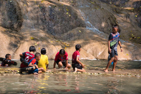 Tenasserim Hills, Sai Yok District of Kanchanaburi Province, Thailand 12.28.2019: Local Thai children and their parents relaxing, playing and enjoying the refreshing waters of the fallのeditorial素材