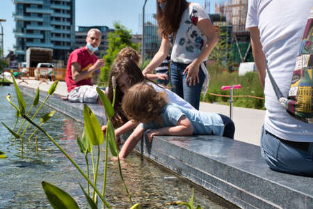 Milan, Italy 06.20.2020: Children enjoying the sun and playing with water in the new Library Of Trees park in Milanのeditorial素材