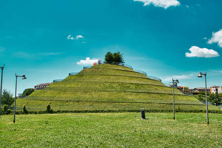 Milan, Italy 08.03.2020: A spiral hill in Portello park with a DNA Monument of Charles Jenks on the...