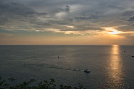 Beautiful, stunning panoramic view of the golden sky and reflections on the Andaman sea during the sunset at Promthep Cape landmark viewpoint in Phuket, Thailandの写真素材