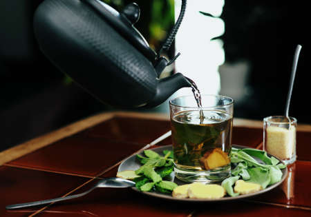 Glass of tea with ginger, mint and sageの写真素材