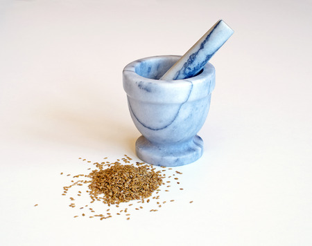 Pile of golden flax seeds, mortar on a white backgroundの写真素材