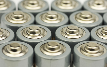 Multiple rows of standing AA batteries with blurred backgroundsの写真素材
