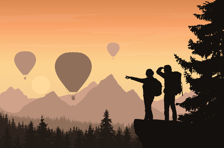 Two hikers looking down into the valley between mountains with forest and flying hot air balloons - vectorのイラスト素材