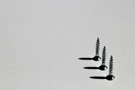 Three upturned screws with 90 degree shadows and white background