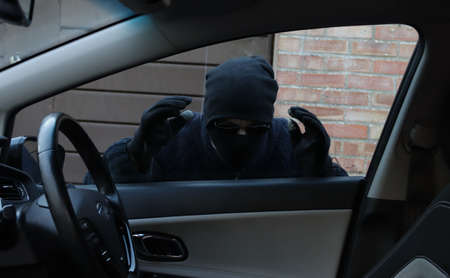Thief looking in through car window with intent to stealの写真素材