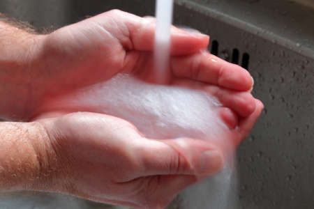 Hands being washed under a tap with long exposureの写真素材