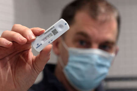 Person holding positive covid lateral flow test resultの写真素材