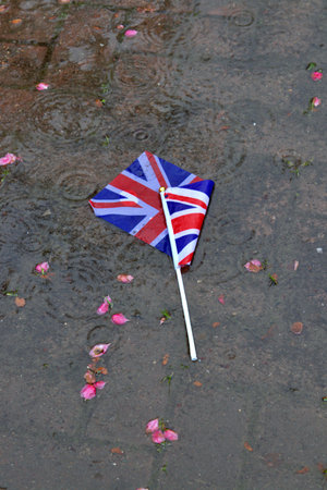 Discarded British flag lying in a puddle after coronationの写真素材