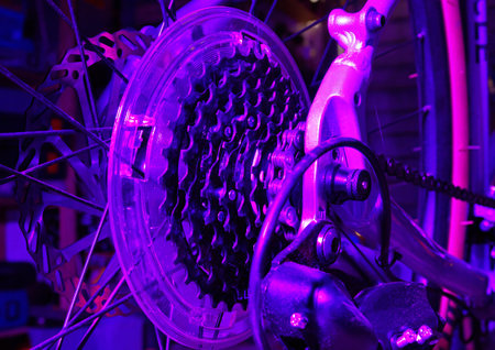 Close up of bicycle gears under a purple lightの写真素材