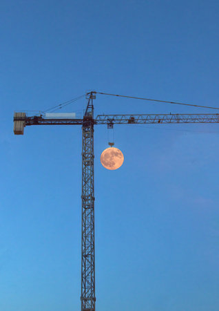 The illusion of the moon being lifted by a craneの写真素材