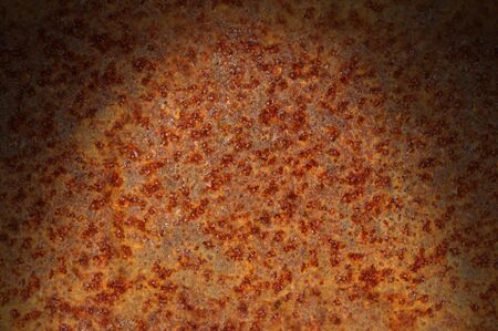 Rusted corroded metal surface dramatically lit from above. Horizontal.