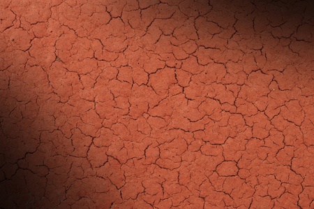 Cracked red textured surface background, dramatically lit diagonallyの写真素材