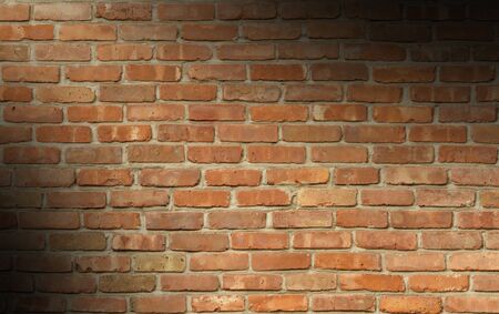 Weathered red brick wall texture lit diagonallyの写真素材