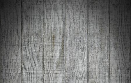 Weathered gray wooden barn siding using vertical planks lit dramatically from aboveの写真素材