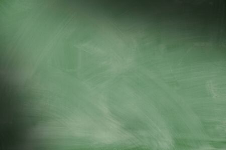Green chalkboard with smeared chalk eraser marks lit diagonallyの写真素材