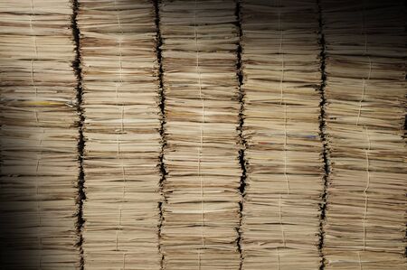 Five uniform piles of newspapers to be recycled lit diagonallyの写真素材