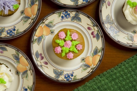 Close-up of ornately decorated cupcakes on dishesの写真素材