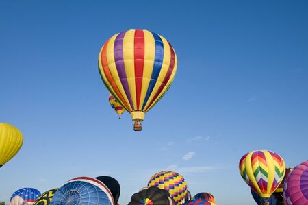 Hot-air balloons ascending over inflating ones on the groundの写真素材