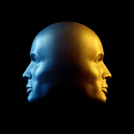 Two-faced head statue with one face gold, the other blue.の写真素材