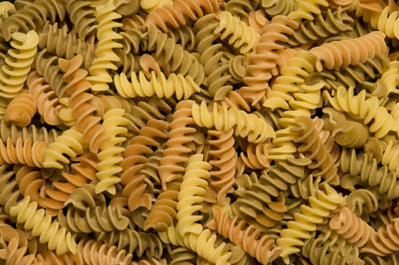 Uncooked multi-colored fusilli, corkscrew-shaped pastaの写真素材