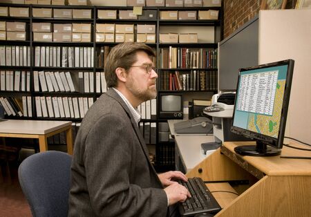 Researcher searching a computer database archives. [Images on the computer screen were created for this photograph.]のeditorial素材