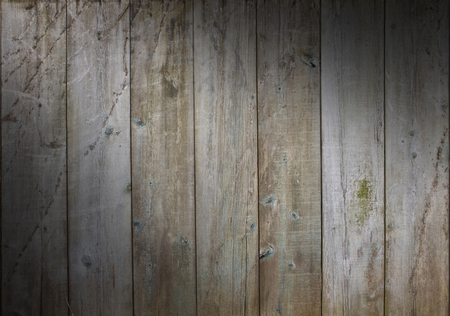 Distressed wooden wall background with weathered boards with scrapes and algae, lit diagonallyの写真素材