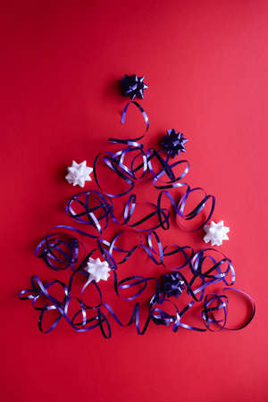 Christmas tree made of shiny blue ribbon with bows.