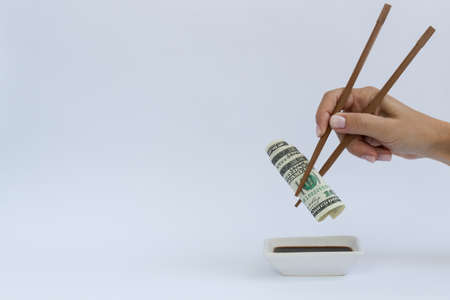 Dollars in a timber chopstick on a white with a copy space.